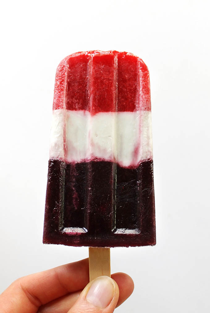 Vegan Red White and Blue Popsicles - These popsicles make the perfect 4th of july - or anytime in the summer treat. Pureed strawberries, coconut milk, and pureed blueberries make the layers. Festive, refreshing, healthy! Refined-sugar-free/gluten free/vegan.