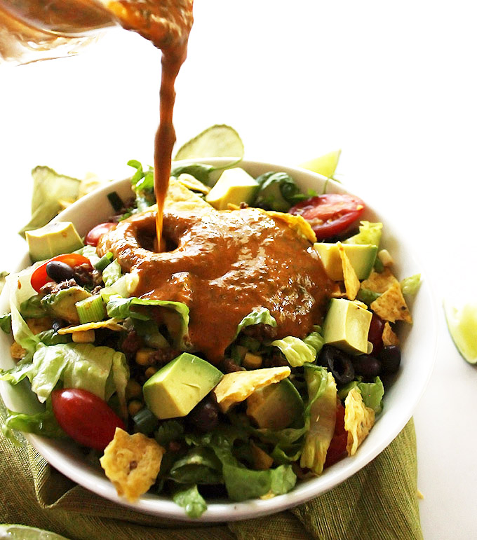 Healthy Taco Salad - Shredded romaine lettuce piled high with ultimate taco fixings. Topped with a simple salsa lime vinagrette! This recipe is perfect for summertime meals! Gluten Free