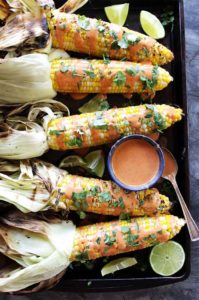 Grilled Corn with Spicy Chipotle Sauce - Sweet corn that's drizzled with this EASY chipotle sauce and topped with cilantro and a squeeze of lime. Perfect for summertime parties! Vegetarian/gluten free.