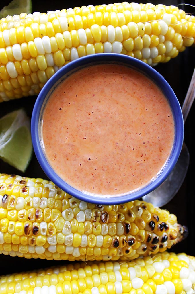 Grilled Corn with Spicy Chipotle Sauce - Grilled sweet corn that's drizzled with sweet/spicy/smoky chipotle sauce and topped with cilantro and a squeeze of lime. EASY to make. This recipe is perfect for summertime parties. Vegetarian/gluten free.