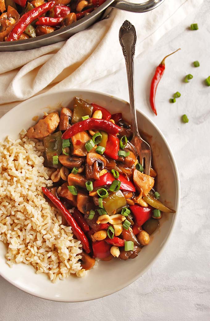 Healthy General Tso's Chicken - Sauteed chicken, onions, peppers, mushrooms, and peanuts in a sweet, salty, spicy sauce that is served over rice. This Asian inspired dish is perfect for weeknight dinners - only takes 30 minutes to make! Gluten Free/Dairy Free/Soy Free | robustrecipes.com