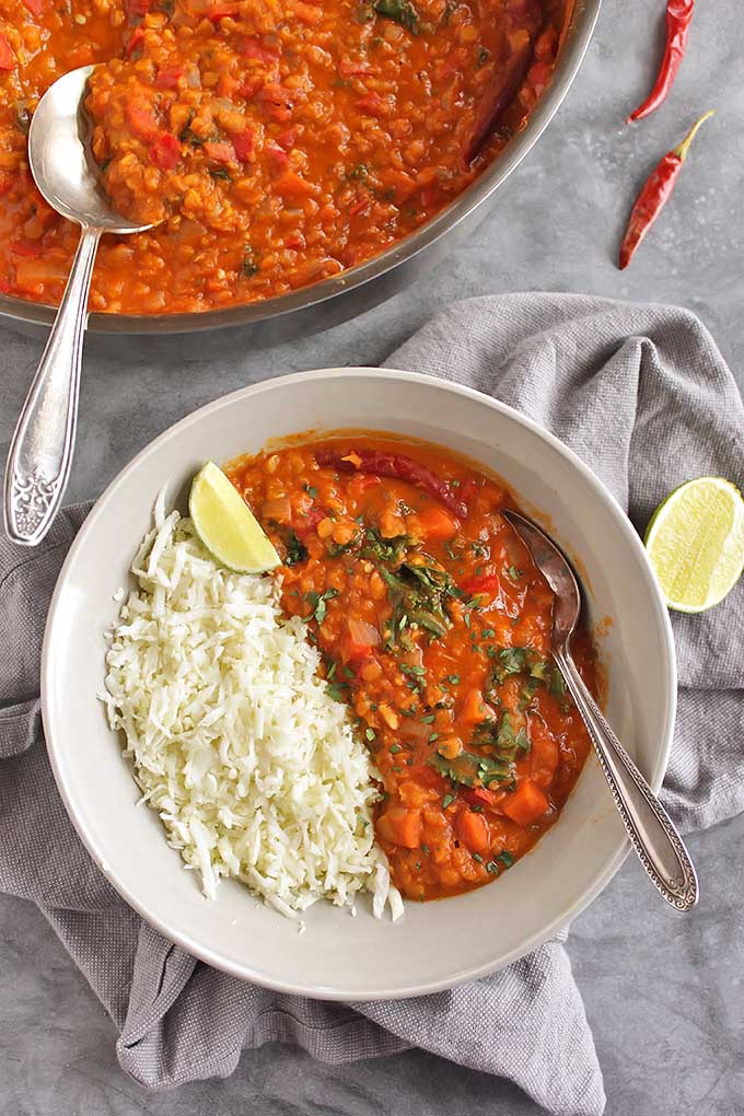 40 Minute Red Lentil Curry with Cauliflower Rice - Warming, creamy, flavorful, and spicy. This recipe is packed with veggies and 13 grams of protein per serving making it a plant based meal that will stick with you for hours. Only takes 40 minutes to make, perfect for a weeknight dinner. Gluten free/vegan/dairy free | robustrecipes.com