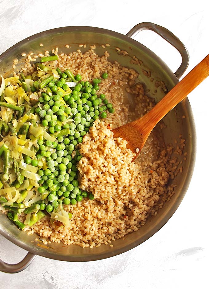 Brown Rice Spring Risotto - Risotto made with brown rice for added health benefits and more texture. This risotto is packed with spring veggies like leeks, asparagus, and peas! This recipe makes a great side dish or add shrimp for a complete meal! Vegetarian/Gluten Free | robustrecipes.com