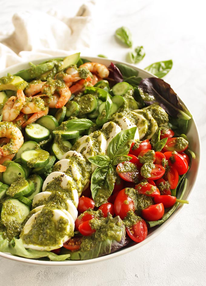 Loaded Caprese Salad with Shrimp - packed with all of the caprese classics plus some extra veggies. The salad is topped with a yummy basil dressing. This recipe only takes 25 minutes to make and is perfect for a quick dinner! Gluten free | robustrecipes.com