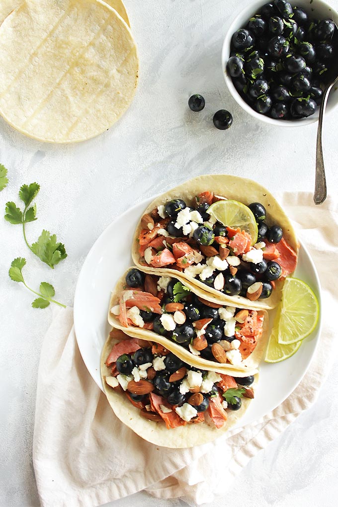 Salmon Tacos with Blueberry Almond Salsa - filled with pan seared salmon and a juicy blueberry almond salsa. The combo will surprise you. This recipe is simple enough for a weeknight meal (only takes 20 minutes to make), but special enough for a weekend meal. Perfect for summer! Gluten Free | robustrecipes.com