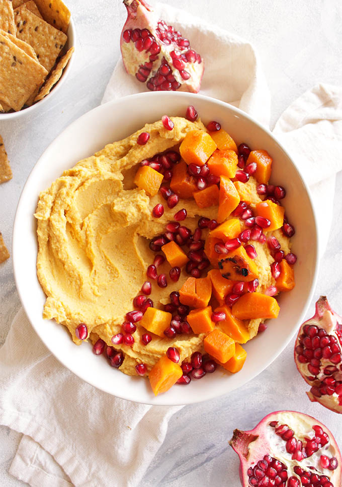 Loaded Butternut Squash Hummus with Pomegranate - Hummus that is packed with roasted butternut squash and topped with more butternut squash chunks and pomegranate seeds. Serve with crackers for dipping. Makes for the perfect Thanksgiving or Christmas appetizer. It's also great because it can mostly be made ahead and served room temperature or cold. (vegan/gluten free) | robustrecipes.com