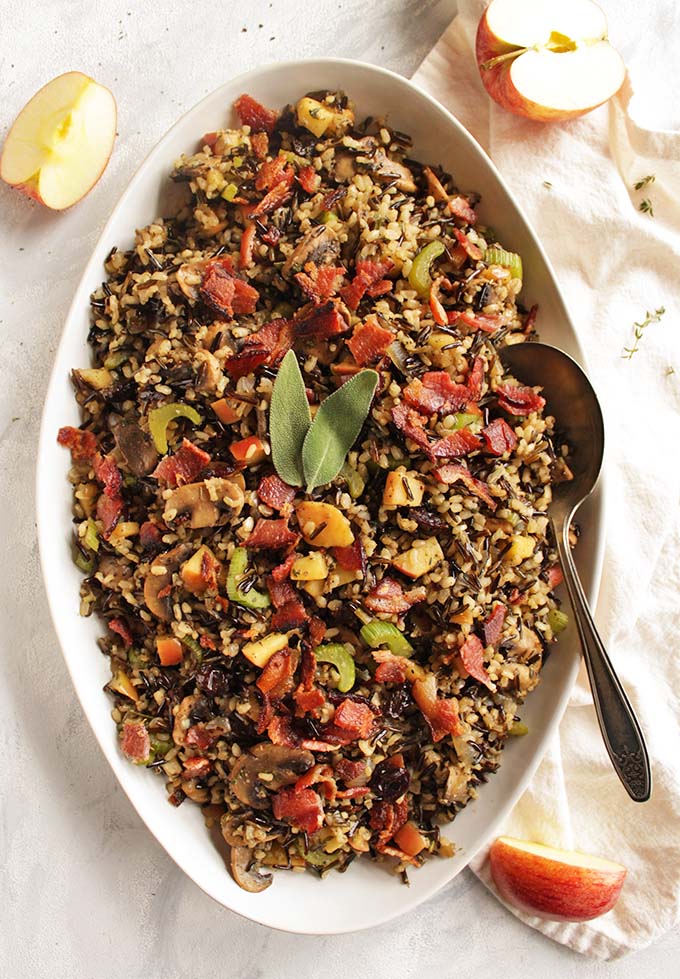 This wild rice mushroom stuffing with bacon makes a perfect side dish for Thanksgiving or Christmas. It's bursting with sweet, salty, and savory flavors. Wild rice plus brown rice make for a great texture. Apples and dried cherries add sweetness! So yum! Plus it can be made a few days ahead of time and reheated the day of! (Gluten Free) | robustrecipes.com