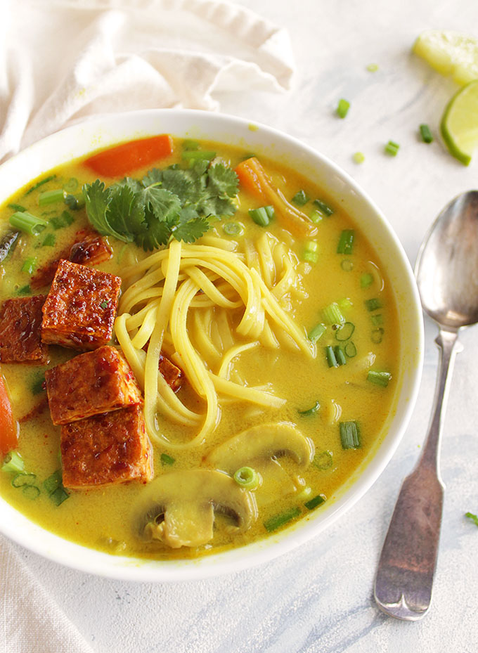 Thai curry soup, sauteed mushrooms, bell peppers, onions, and rice noddles in a creamy curry broth. And topped with crispy tofu. Only takes 30 minutes to make, the perfect weeknight dinner recipe, especially in the winter! (Vegan, Gluten Free, Vegetarian) | robustrecipes.com