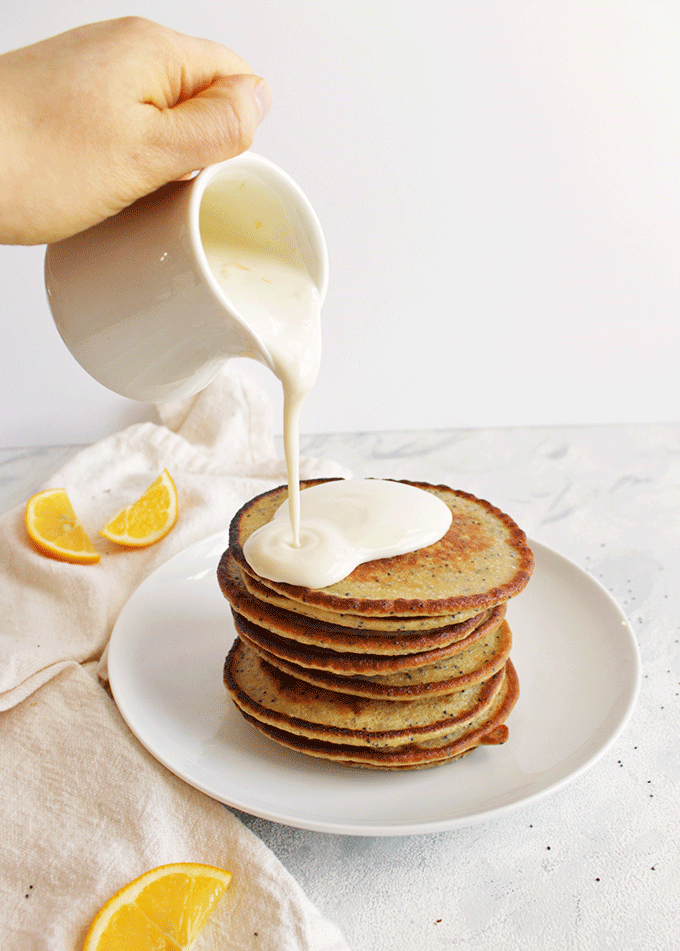 Super yummy lemon protein pancakes packed with healthy ingredients and topped with a creamy lemon Greek yogurt sauce! Made using oats for complex carbs and only sweetened with real maple syrup - low in sugar. Perfect breakfast for weekends!! (Gluten Free/Refined Sugar Free) | robustrecipes.com