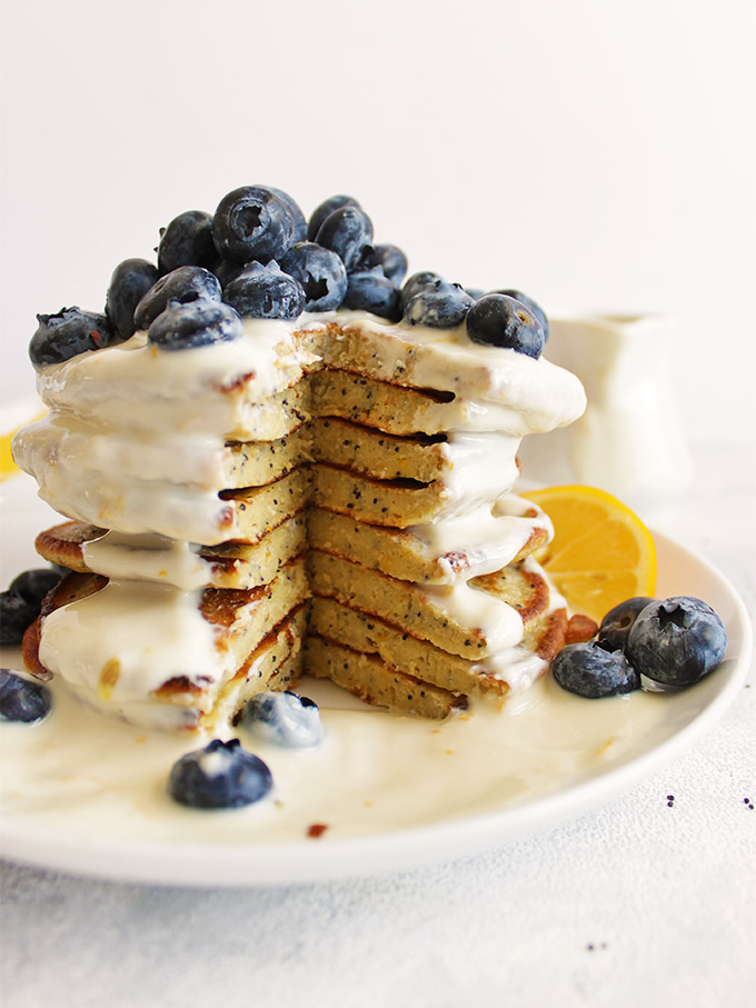 Super yummy lemon protein pancakes packed with healthy ingredients and topped with a creamy lemon Greek yogurt sauce! Made using oats for complex carbs and only sweetened with real maple syrup - low in sugar. Perfect breakfast for weekends!! (Gluten Free/Refined Sugar Free) | robustrecipes.com