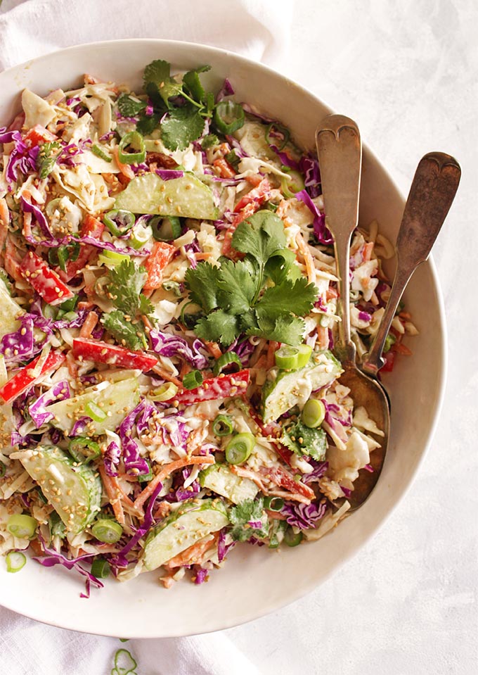 Super Easy Thai crunch salad with Tahini Dressing - packed with a variety of hearty veggies: green and purple cabbage, carrots, bell pepper, cucumbers. It's perfect for making in advance (no soggy lettuce) and for bringing to parties! Plus, it only takes 15 minutes to make! (Gluten Free/vegan/vegetarian) | robustrecipes.com