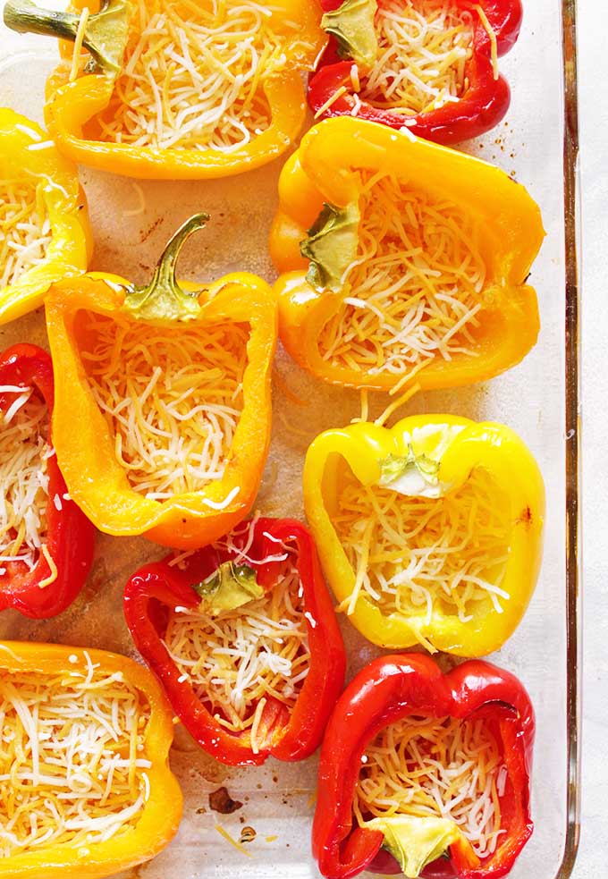 Chicken Enchilada stuffed peppers are peppers stuffed with all the traditional enchilada ingredients - a fun and healthy twist. The perfect recipe for any party Cinco de Mayo or Mexican themed party! They also re-heat nicely making this a great meal prep recipe! (Gluten Free) | robustrecipes.com