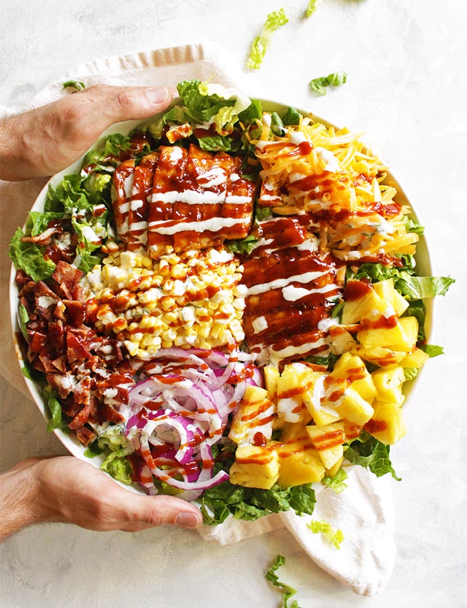 BBQ chicken salad is loaded with grilled BBQ chicken, corn, pineapple, smoked cheddar cheese, BACON, and topped with a homemade Greek yogurt ranch dressing and more BBQ sauce. The perfect dinner salad for summer! #BBQchicken #salad #chicken #summersalad #bacon #glutenfree | robustrecipes.com