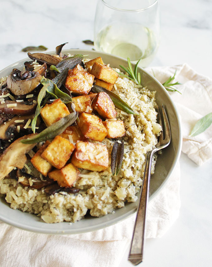 Mushroom cauliflower risotto with crispy tofu- a lighter and veggie loaded alternative to regular risotto. It's packed with hearty herbs and topped with crispy tofu for a complete meal. Perfect for fall! #glutenfree #vegetarian #recipes #cauliflower #dinner | robustrecipes.com