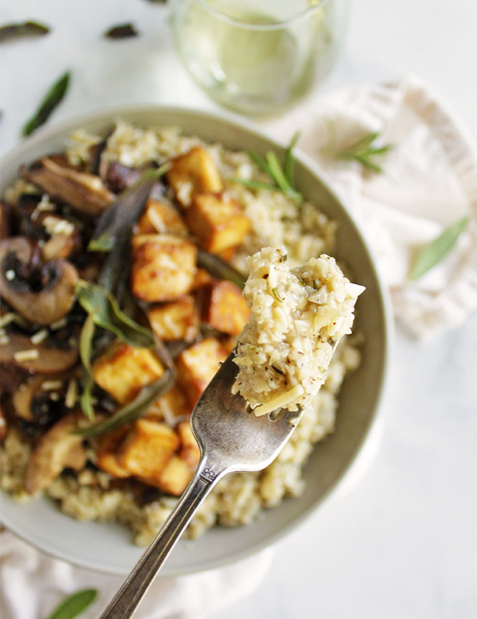 Mushroom cauliflower risotto with crispy tofu- a lighter and veggie loaded alternative to regular risotto. It's packed with hearty herbs and topped with crispy tofu for a complete meal. Perfect for fall! #glutenfree #vegetarian #recipes #cauliflower #dinner | robustrecipes.com