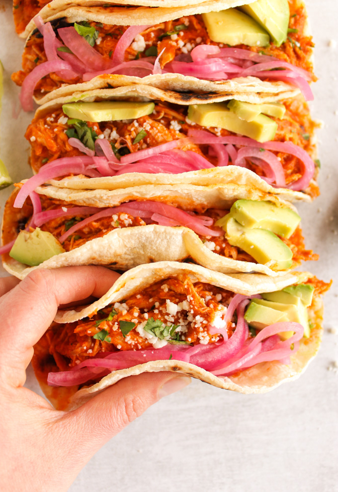 Smoky Instant Pot Chicken Tinga Tacos - chicken tacos coated in a smokey, slightly spicy, tomato sauce and served taco style with pickled red onions, avocado, and cotija cheese.  Easy 30 minute meal. #tacos #chicken #instantpot #mexicanfood #weeknightdinner #easymeal