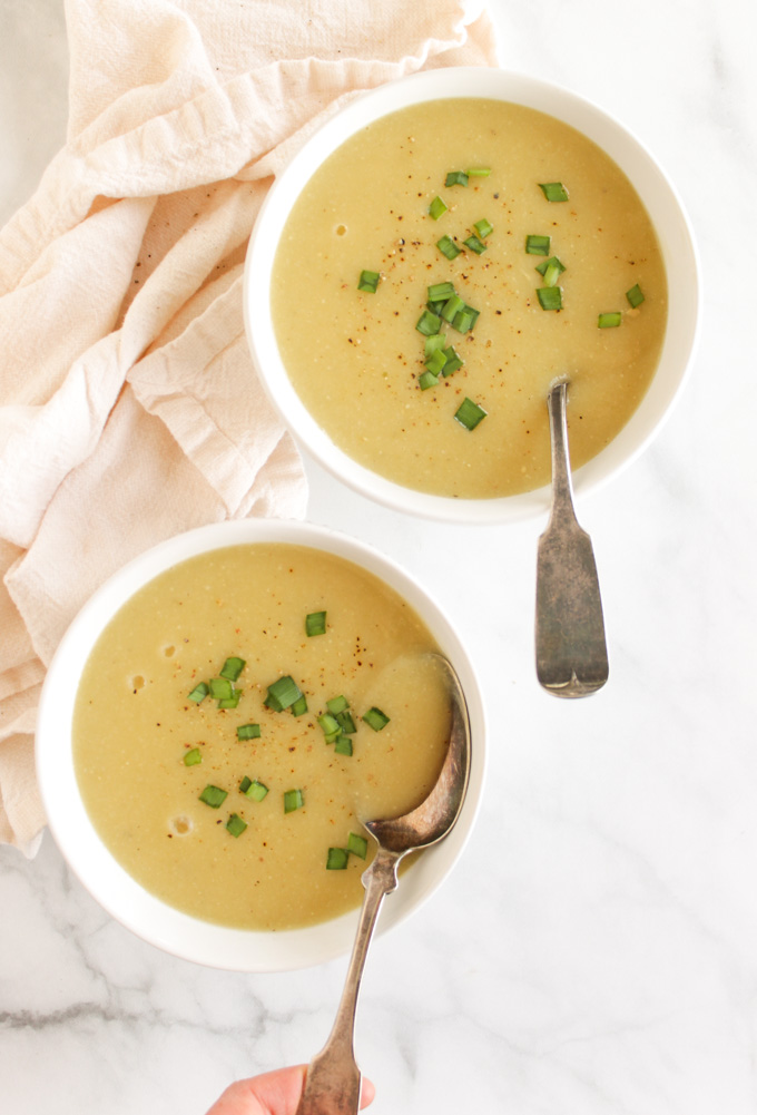 Healthy Creamy leek and potato soup only takes 30 minutes to make. It doesn't contain any cream, instead cauliflower helps to make it creamy. Satisfying and delicious with any meal. #glutenfree #vegan #vegetarian #soup #easyrecipe  | robustrecipes.com