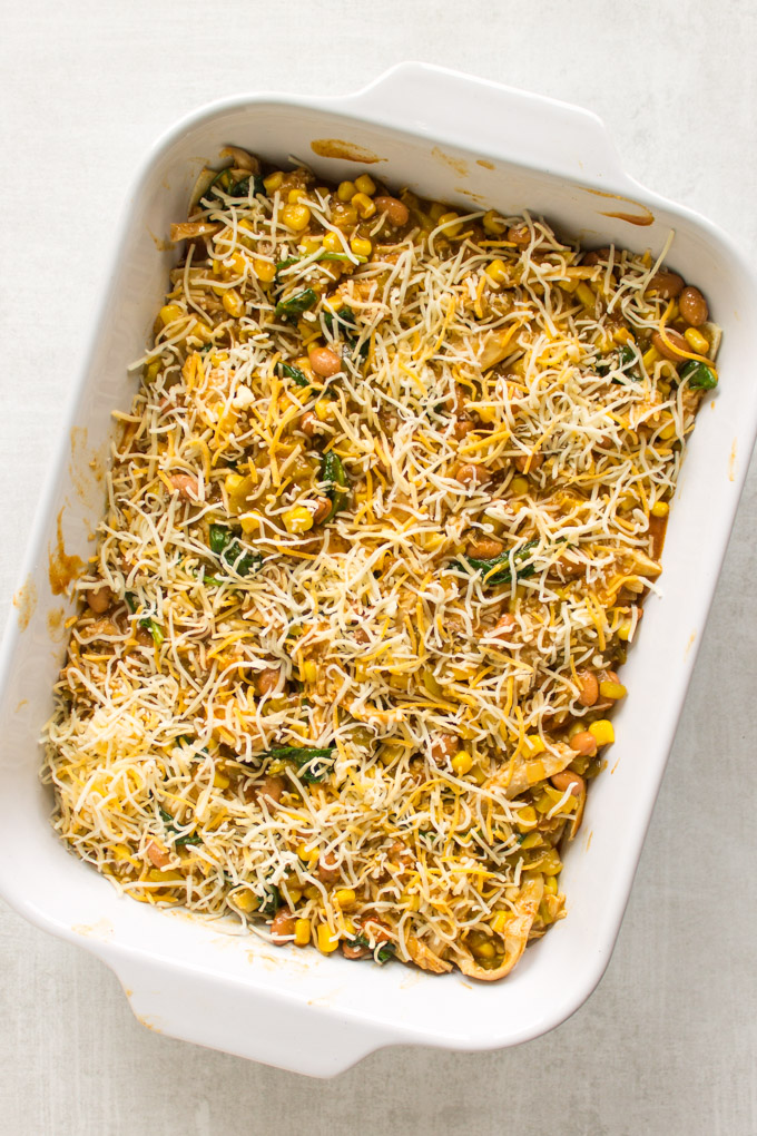 Easy Chicken Enchilada Casserole - all the enchilada flavors made into a casserole that's layered with corn tortillas. This casserole is perfect for feeding a crowd or meal prep. Makes great leftovers. #chicken #recipe #enchiladas #Mexicanfood #cincodemayo #glutenfree #corn #cleaneating #healthyfood #cheese #mealprep | robustrecipes.com