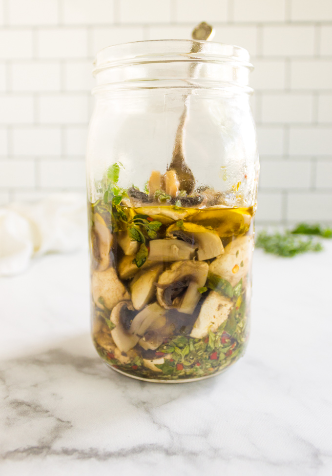 Herbed Marinated Mushrooms - tangy, herby, and delish. They are a great way to add flavor to salads, cheese boards, or as pizza toppings. #easyrecipe #mushrooms #marinated #pickled #herbs #appetizer #condiments #cheeseboard #glutenfree #dairyfree #vegan #vegetarian #healthy | robustrecipes.com