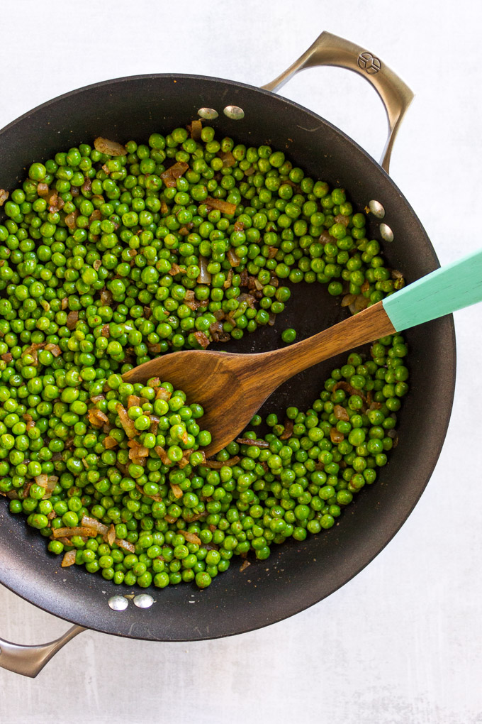 Indian Spiced Peas - Indian spiced peas are a super easy and delicious side dish to serve with any Asian inspired entree. The only require one pan, 20 minutes, and a few simple ingredients. #peas #glutenfree #dairyfree #vegan #sidedish #onepan #easyrecipe #Indian #onions | robustrecipes.com