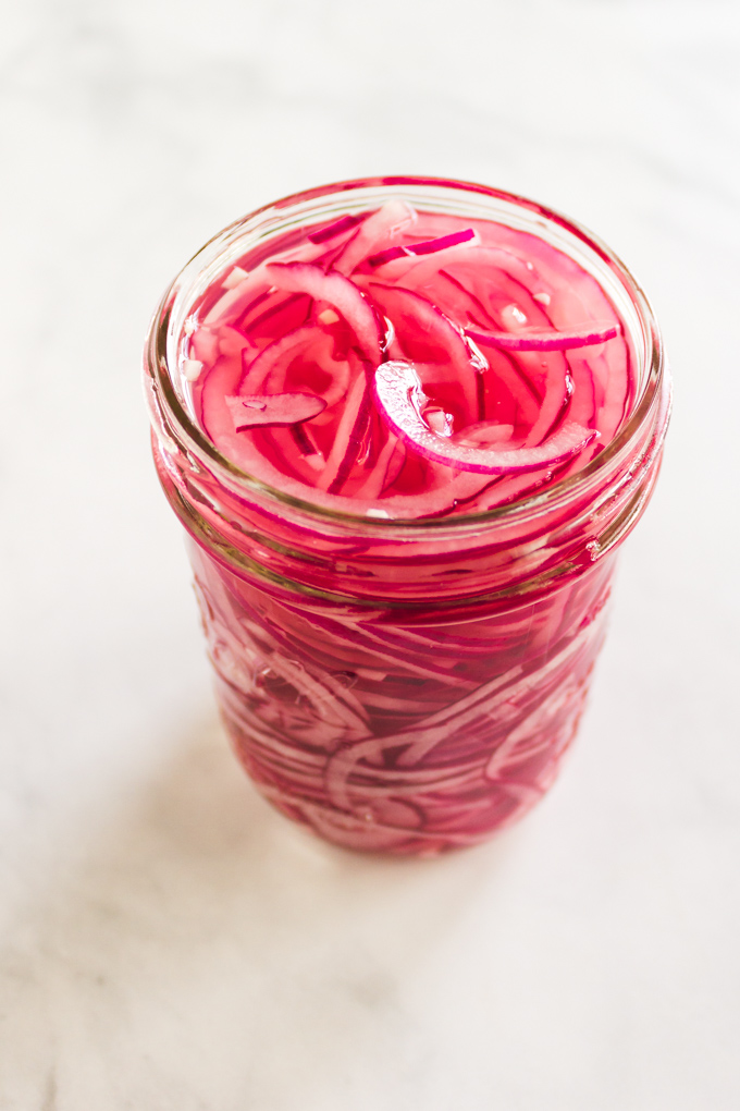 Quick Pickled Red Onions - a simple way to add a tangy, crunchy texture with a mild onion flavor to almost any recipe. Add to salads, tacos, grain bowls, pizzas, or fajitas - the possibilities are endless. #pickledonions #condiments #glutenfree #easyrecipe #dairyfree #vegan #vegetarian #pizza #salads #appetizer #sandwiches #tacos | robustrecipes.com