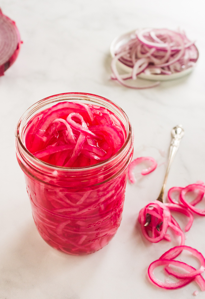 Quick Pickled Red Onions - a simple way to add a tangy, crunchy texture with a mild onion flavor to almost any recipe. Add to salads, tacos, grain bowls, pizzas, or fajitas - the possibilities are endless. #pickledonions #condiments #glutenfree #easyrecipe #dairyfree #vegan #vegetarian #pizza #salads #appetizer #sandwiches #tacos | robustrecipes.com