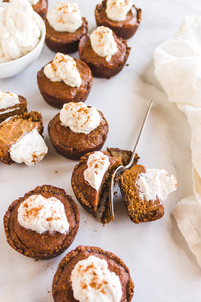Mini Pumpkin Pies with Ginger Cookie Crust (Bourbon & Maple Infused) - The perfect Thanksgiving or Holiday dessert. Topped with homemade maple bourbon whipped cream they are the ultimate personal-sized dessert. #pumpkinpie #Thanksgivingrecipe #Thanksgiving #pumpkin #pumpkinpiespice #gingerbread #minipumpkinpie #glutenfree #dairyfree #bourbon #Thanksgivingdessert #whippedcream #maplesyrup #dessert #refinedsugarfree | robustrecipes.com