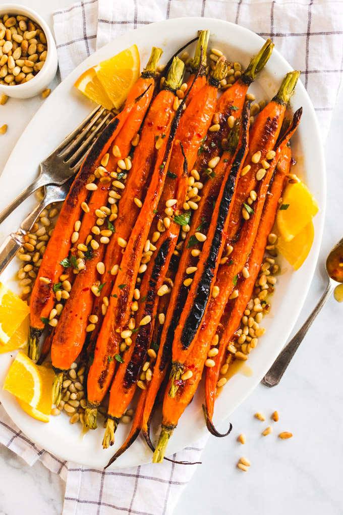 Easy roasted carrots with orange honey glaze and toasted pine nuts is the perfect side dish for any Holiday or dinner party. #carrots #roastedcarrots #sidedish #easysidedish #holiday #honey #orange #pinenuts #glutenfree #vegetarian #dairyfree #easyrecipe | robustrecipes.com