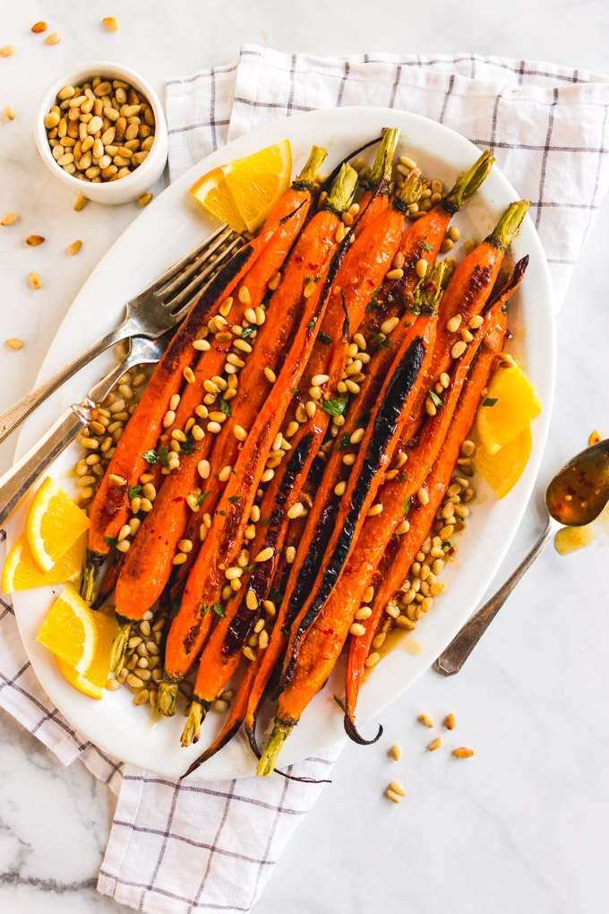 Easy roasted carrots with orange honey glaze and toasted pine nuts is the perfect side dish for any Holiday or dinner party. #carrots #roastedcarrots #sidedish #easysidedish #holiday #honey #orange #pinenuts #glutenfree #vegetarian #dairyfree #easyrecipe | robustrecipes.com