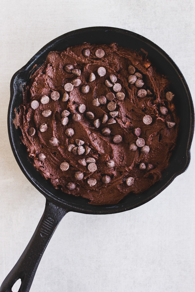 This flourless skillet brownie uses black beans to create a fudgy, vegan brownie you will love. Served warm, straight from the oven with vanilla ice cream for the ultimate chocolate dessert. #pantrystaples #brownierecipe #glutenfreebaking #veganbrownies #blackbeanbrownies #chocolaterecipe #dairyfreerecipe #blackbeans #chocolatechips #icecream #dessert | robustrecipes.com