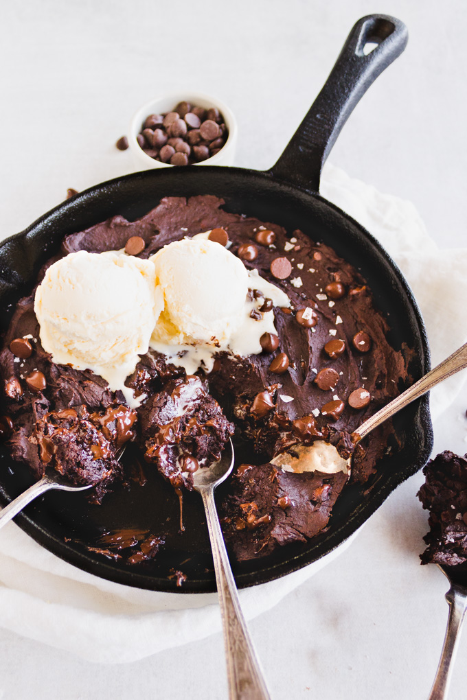 This flourless skillet brownie uses black beans to create a fudgy, vegan brownie you will love. Served warm, straight from the oven with vanilla ice cream for the ultimate chocolate dessert. #pantrystaples #brownierecipe #glutenfreebaking #veganbrownies #blackbeanbrownies #chocolaterecipe #dairyfreerecipe #blackbeans #chocolatechips #icecream #dessert | robustrecipes.com