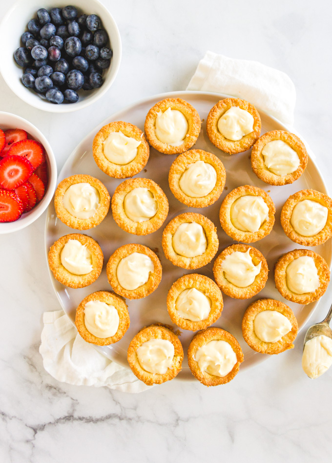 Lemon Cheesecake Cookie Cups with Berries - a sugar cookie cup that's filled with a lemon cream cheese frosting and topped with your choice of berries. They are festive enough for the 4th of July, or any summer party when fresh berries are at their peak. #glutenfreecookies #glutenfreerecipe #berries #creamcheese #dessert #cookies #4thofjuly | robustrecipes