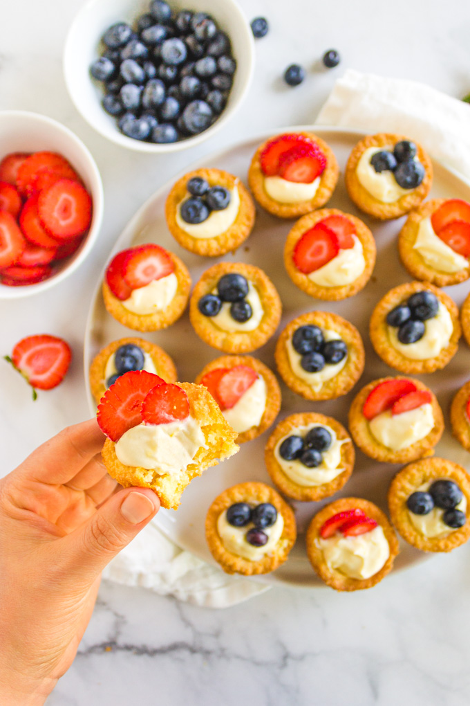 Lemon Cheesecake Cookie Cups with Berries - a sugar cookie cup that's filled with a lemon cream cheese frosting and topped with your choice of berries. They are festive enough for the 4th of July, or any summer party when fresh berries are at their peak. #glutenfreecookies #glutenfreerecipe #berries #creamcheese #dessert #cookies #4thofjuly | robustrecipes