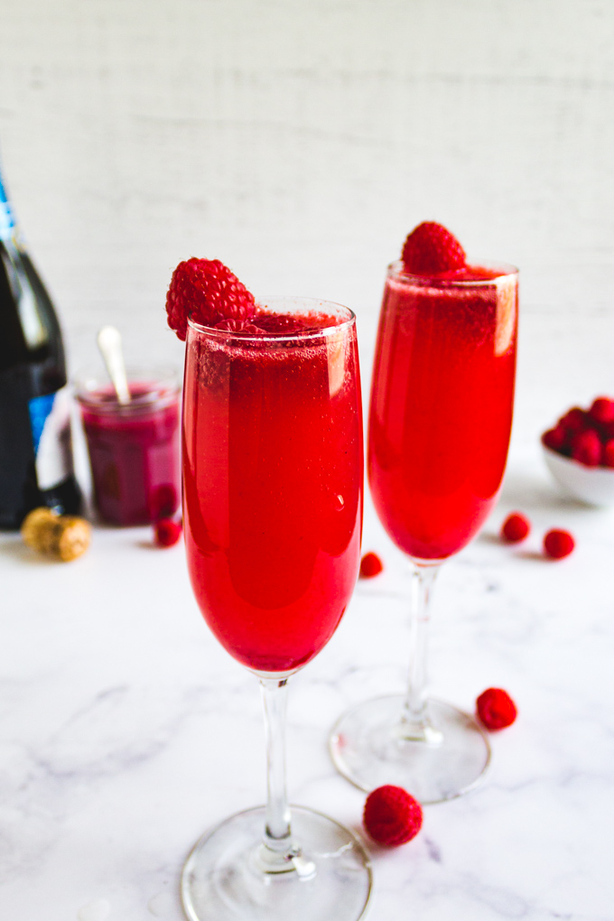 2 Raspberry bellnis on a white background with raspberry garnishes.