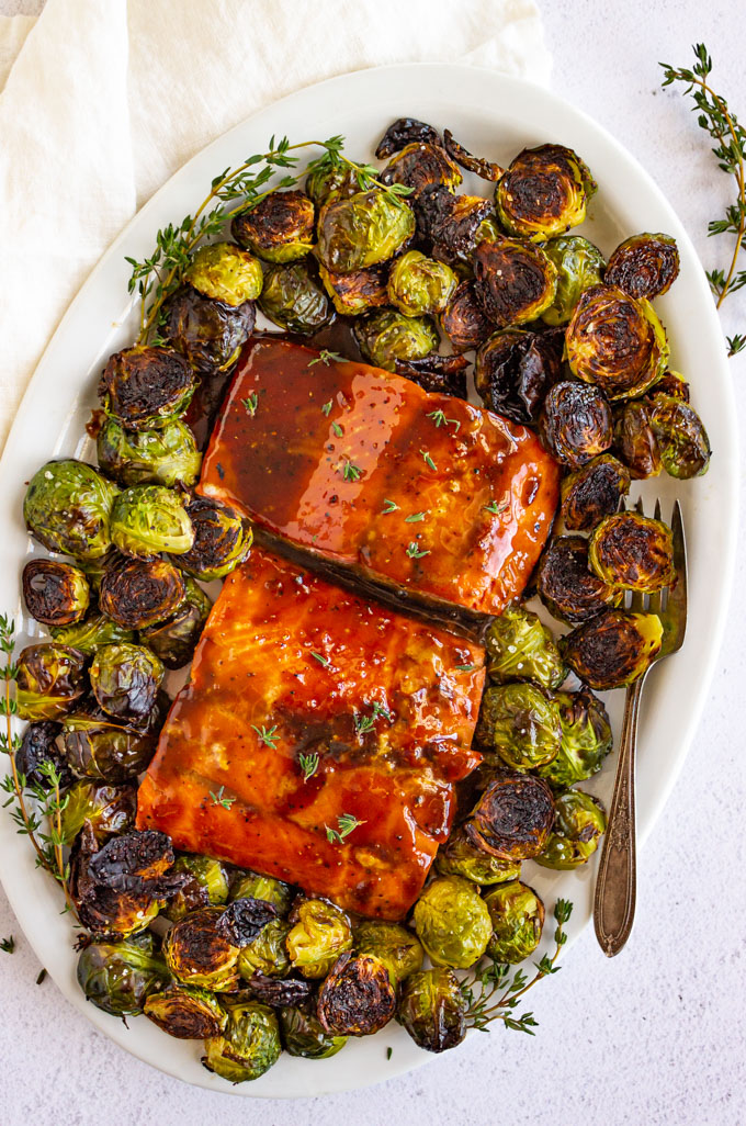 maple glazed salmon on an oval plate with brussels sprouts, overhead shot.
