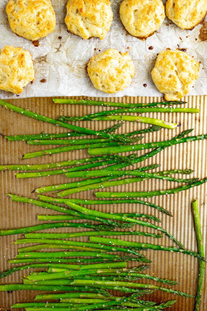 Roasted asparagus and buttermilk drop biscuits on a sheet pan.