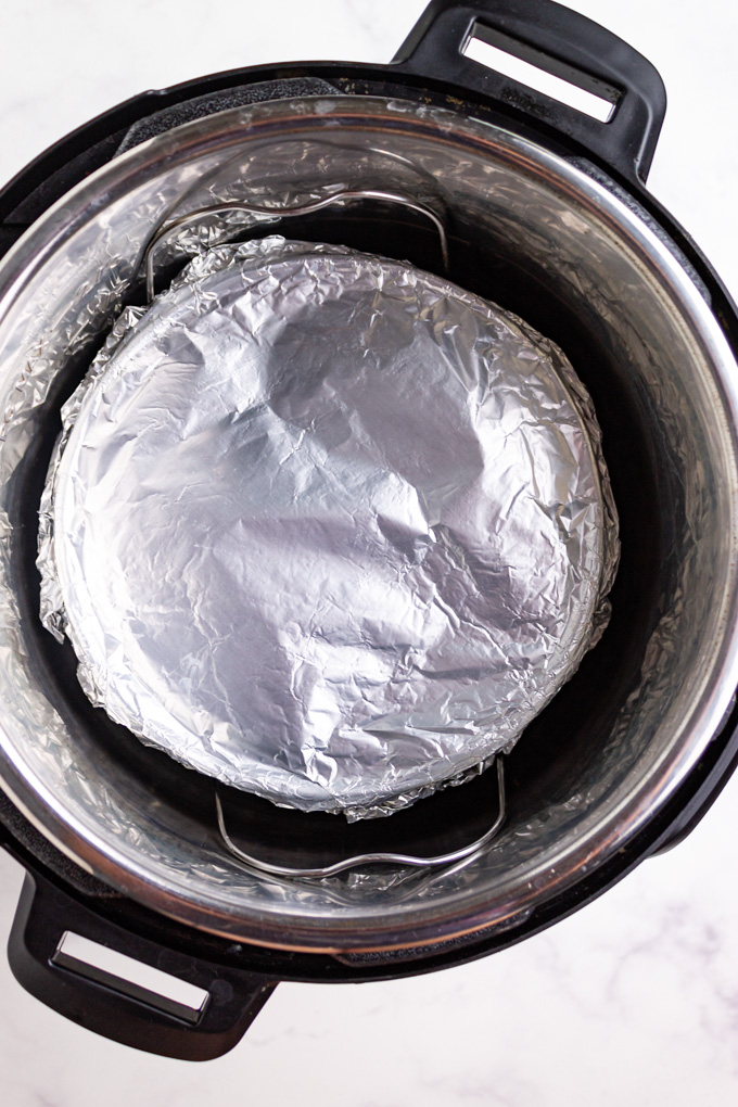 cheesecake in an instant pot with foil over top.