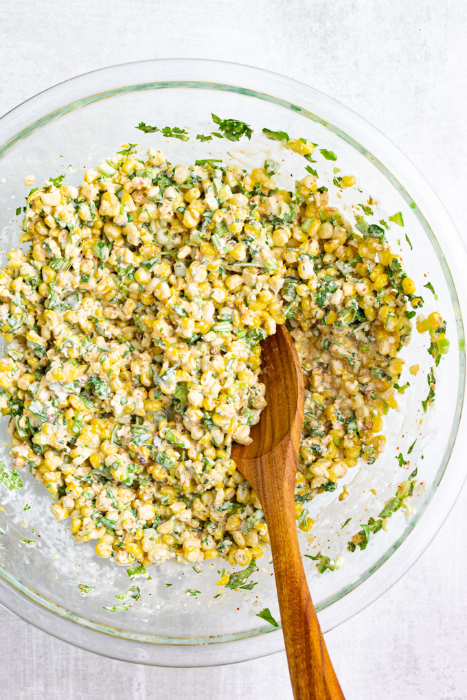 Mexican street corn salad mixed up together in a mixing bowl.