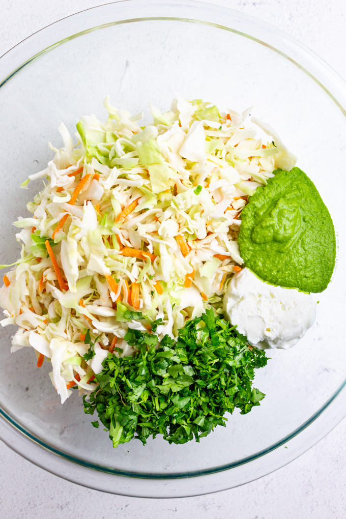 ingredients for jalapeno cilantro slaw in a mixing bowl.