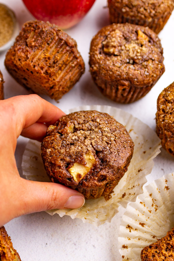closeup of apple butter muffins with a hand grabbing a muffin.