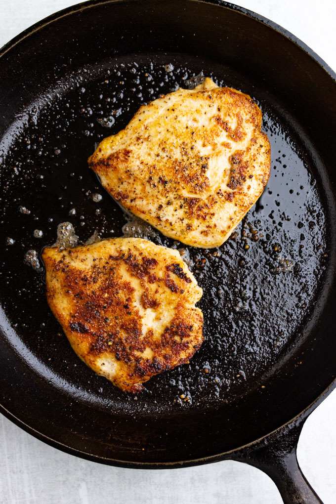 chicken breasts cooked in a cast iron skillet.