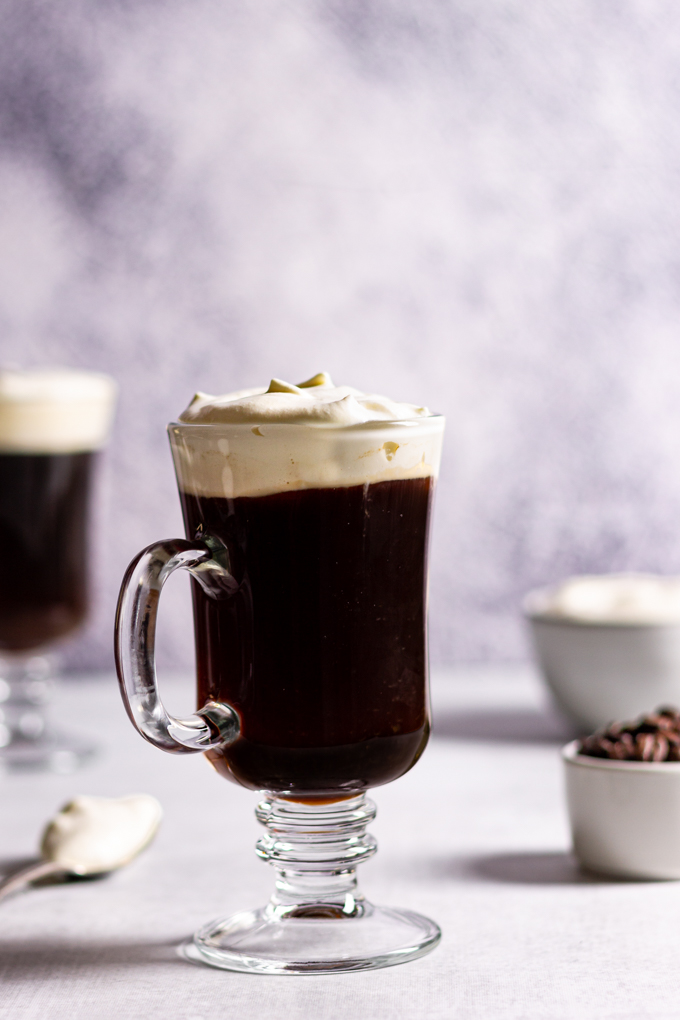 Easy Irish coffee in a clear mug with a second glass in the background.