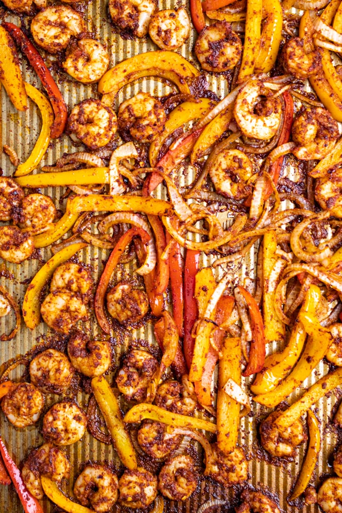 Shrimp and bell peppers coated in fajita seasoning, cooked on a sheet pan.