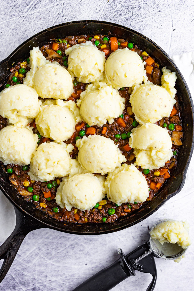 shepherd's pie with spoonfuls of mashed potatoes on top.