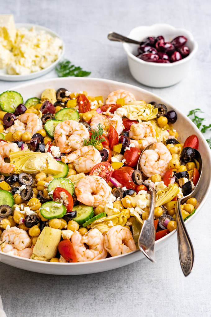 An angled shot of Greek chickpea salad with shrimp in a serving bowl.