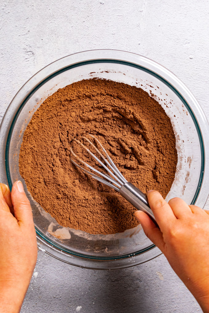 Cocoa powder mix is being whisked up in a mixing bowl.