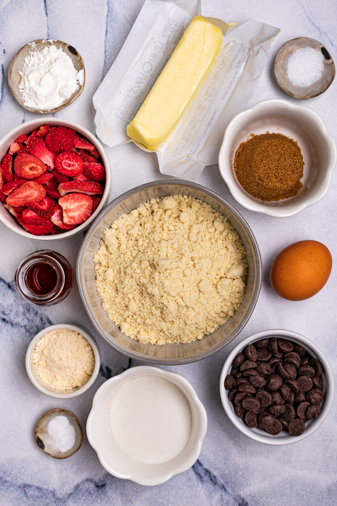 Ingredients in bowls: almond flour, sugar, brown sugar, butter, egg, chocolate chips, freeze dried strawberries.