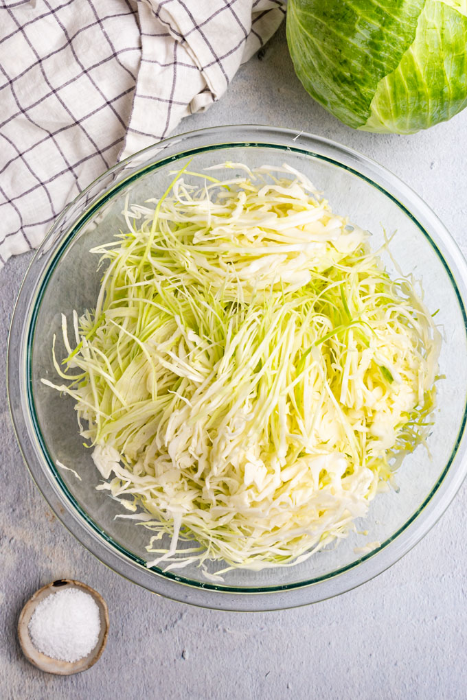 Shredded cabbage in a bowl for how to make sauerkraut.