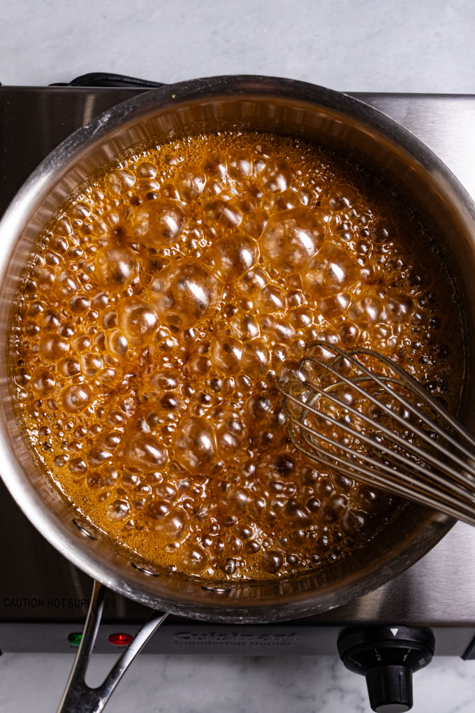 Overhead photo of honey glaze for ham being simmered in a sauce pan