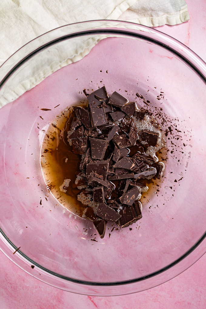 Browned butter in a glass mixing bowl along with chopped dark chocolate.